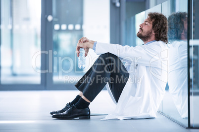 Worried doctor sitting on floor