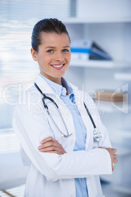 Portrait of a smiling female doctor standing with arms crossed