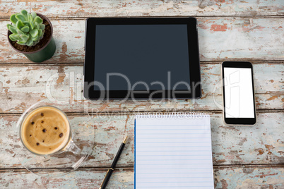 Digital tablet with smartphone, pot plant, pen, notepad and coffee cup