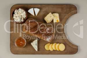 Variety of cheese with bread and sauce on chopping board