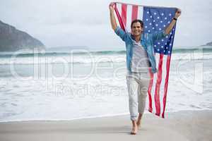 Man holding american flag on beach
