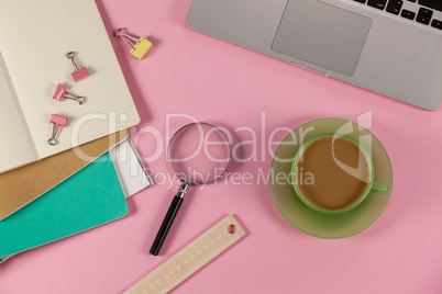 Cup of tea, laptop, magnifying glass, diaries, ruler and paper clips