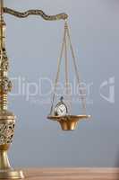 Conceptual image of pocket watch on justice scale