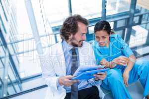 Happy doctor and nurse discussing over a report