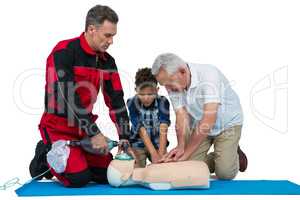 Paramedic training cardiopulmonary resuscitation to senior man and boy