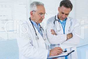 Doctors discussing over clipboard