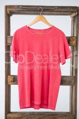 Pink t-shirt hanging on wooden frame