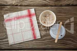 Coffee in disposable cup with tissue paper