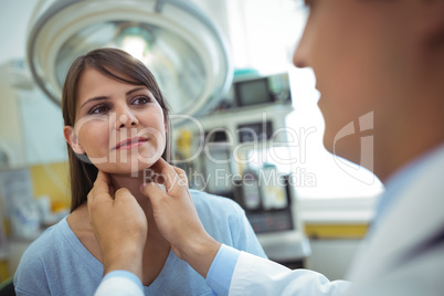 Doctor examining a female patients neck