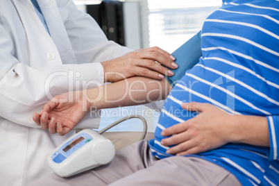 Female doctor checking blood pressure of a patient