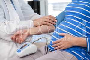 Female doctor checking blood pressure of a patient