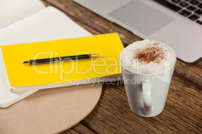 Coffee mug, diary, pen and laptop