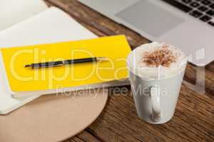 Coffee mug, diary, pen and laptop