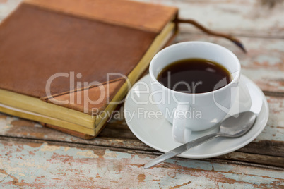 Cup of coffee with organiser on wooden table