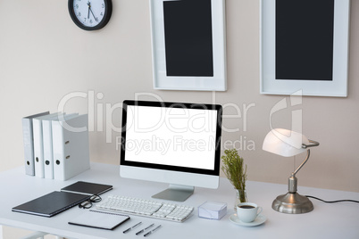 Desktop pc on desk with picture frames on wall