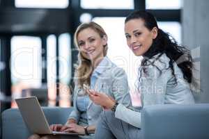Businesswomen holding smart phone and laptop