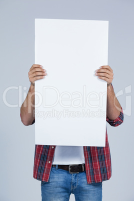 Man holding a blank placard in front of his face