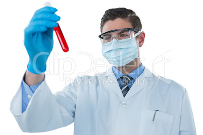 Doctor wearing protective glasses and surgical mask holding a test tube