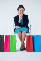 Woman sitting with colorful shopping bags