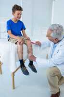 Doctor examining the knee of patient