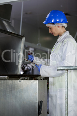 Technician examining meat processing machine