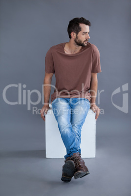 Man in brown t-shirt sitting on a block