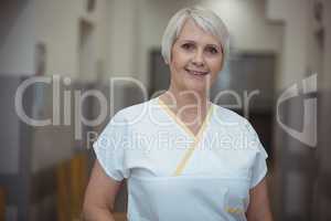 Portrait of female nurse standing in corridor