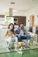 Happy couple watching tv together