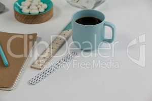 Coffee mug, ruler, diary, pen and pebbles