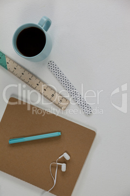 Coffee mug, ruler, diary, pen and earphones
