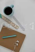 Coffee mug, ruler, diary, pen and earphones