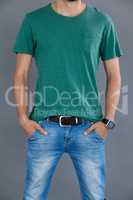 Man in green t-shirt posing with hands in pockets