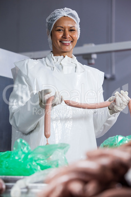 Female butcher processing sausages