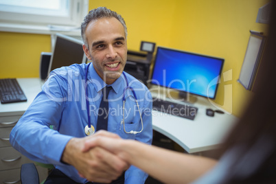 Doctor shaking hand with patient during visit
