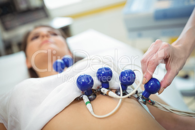 Doctor attaching sensors on the patient for electrocardiogram test