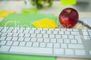 Sticky note, apple and keyboard on office desk