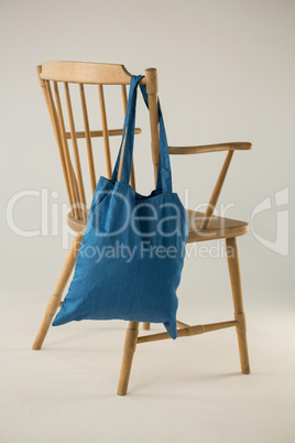 Blue bag hanging on a wooden chair