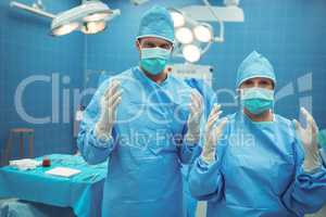 Portrait of male and female surgeon standing in operation theater