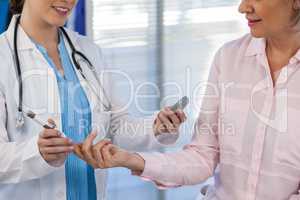 Doctor checking glucose level in diabetic patient