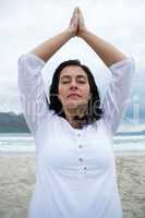 Woman performing yoga on beach