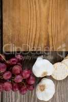 Close-up of garlic, grapes, cracker biscuit and chopping board