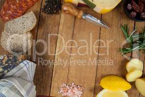 Cheese, ham and bread with various ingredients on chopping board