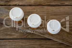 Disposable coffee cups on wooden plank