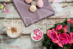 Flower vase, macaroons and cup of coffee