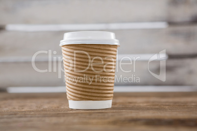 Disposable coffee cup on wooden table