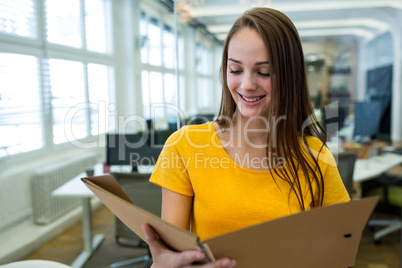 Female business executive reading file in office