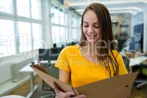 Female business executive reading file in office