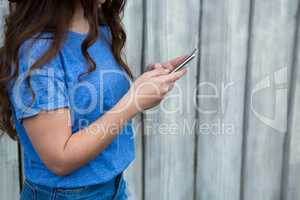 Woman in blue top using mobile phone