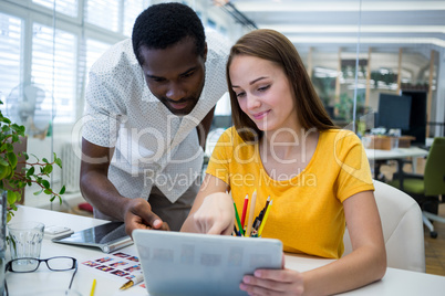 Graphic designers working over digital table at desk