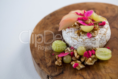 Brie cheese, grapes and nuts on wooden board
